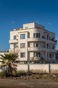 Buildings in city against clear blue sky