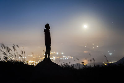 Silhouette man standing against sky at night