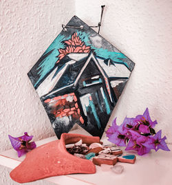 Close-up of flowers on table against wall