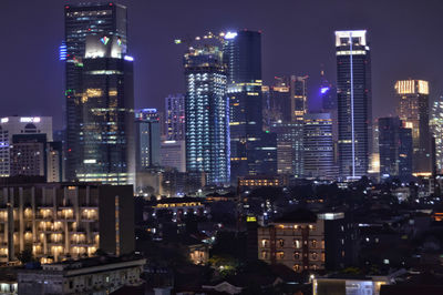 Illuminated buildings against sky at night