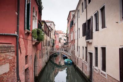 Canal amidst buildings against sky