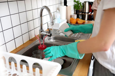 Midsection of woman working in kitchen at home