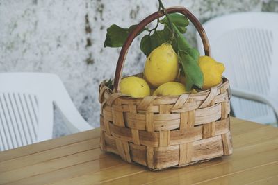 Close-up of lemons in basket on table