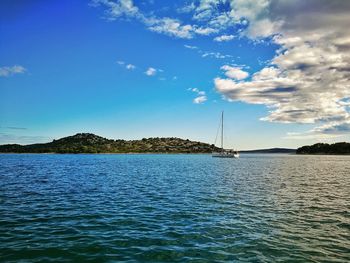 Sailboats sailing in sea against sky