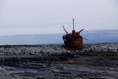 Abandoned ship in sea against sky