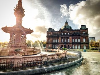 Statue of fountain in city against sky