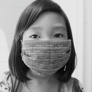 Close-up portrait of a woman covering face