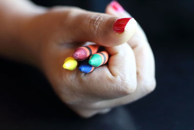 Cropped hand holding crayons