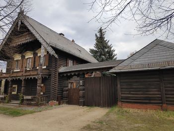 Old house by building against sky