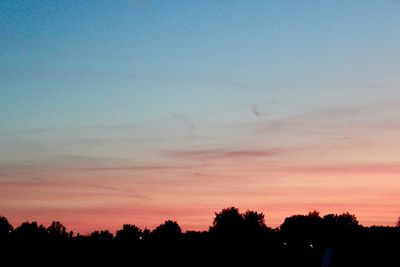 Silhouette trees against sky at sunset