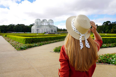 Beautiful stylish woman with hat visiting the botanical garden of curitiba, brazil