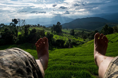 Low section of man on land against sky