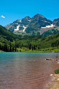 Scenic view of lake and mountains against blue sky
