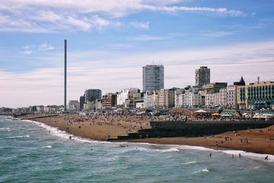 Sea by cityscape against sky