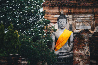 Statue against trees and building