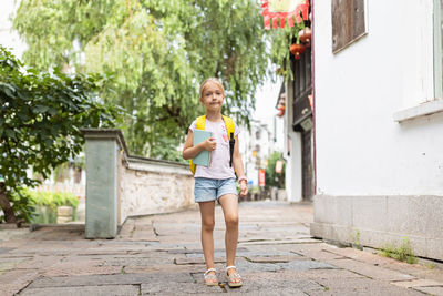 Full length of boy standing on footpath