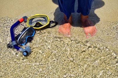 Low section of man standing on sand