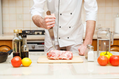 Midsection of man preparing food in kitchen