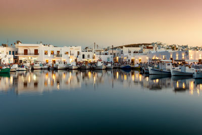 Boats moored in harbor against buildings in city