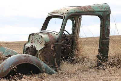 Abandoned semi-truck on field against sky