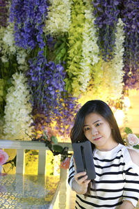 Portrait of beautiful woman standing by plants