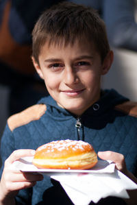 Portrait of cute smiling boy with sweet food in plate