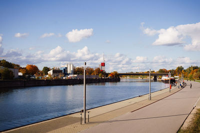 Buildings by river against sky