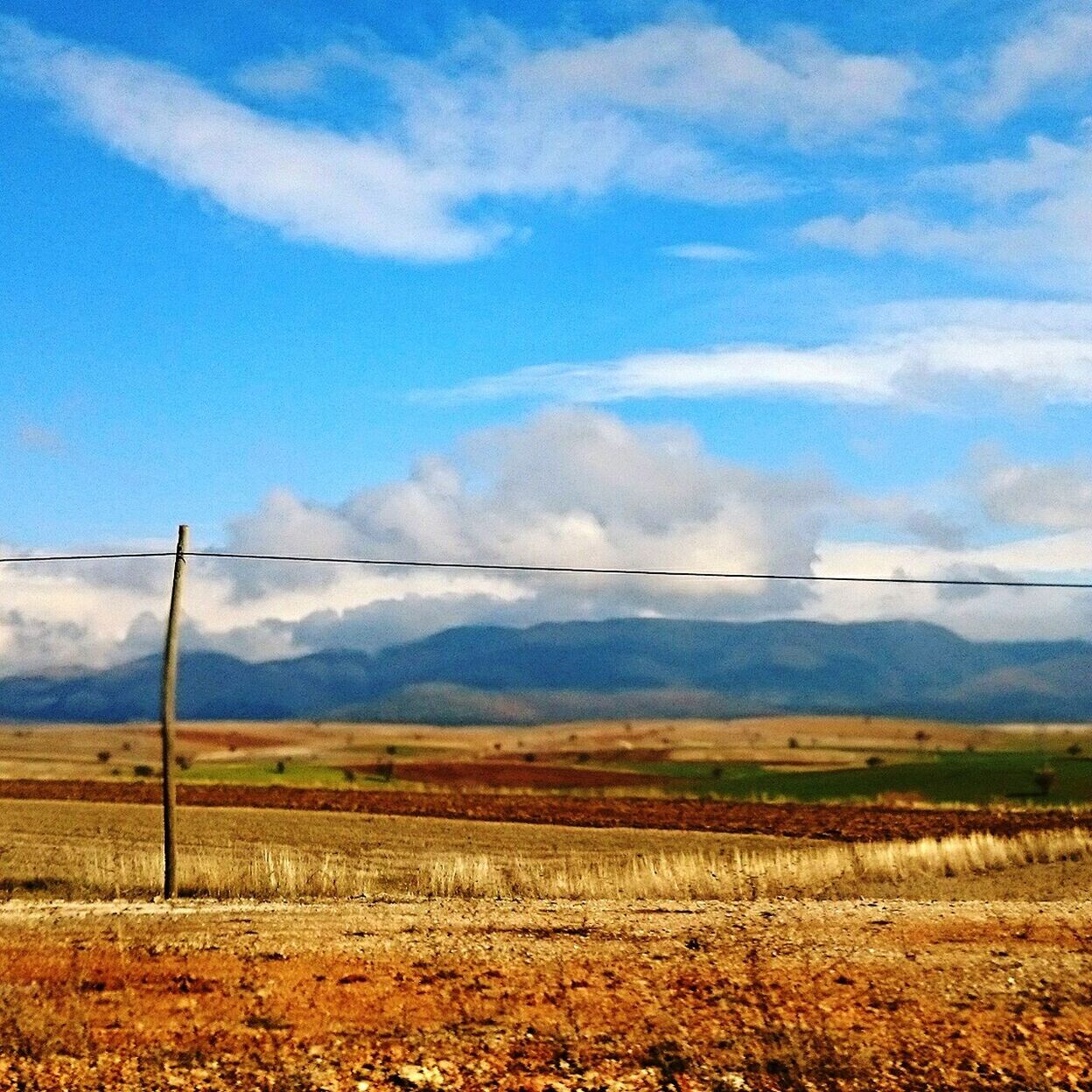 landscape, power line, field, fuel and power generation, sky, electricity pylon, tranquil scene, rural scene, electricity, tranquility, power supply, scenics, agriculture, nature, beauty in nature, mountain, cloud - sky, cable, farm, cloud