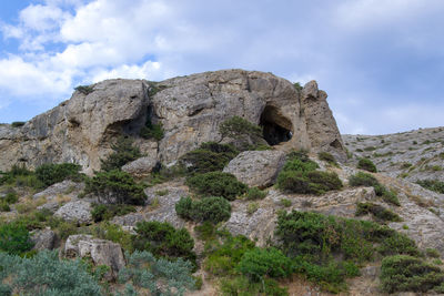 Low angle view of rocks on mountain against sky