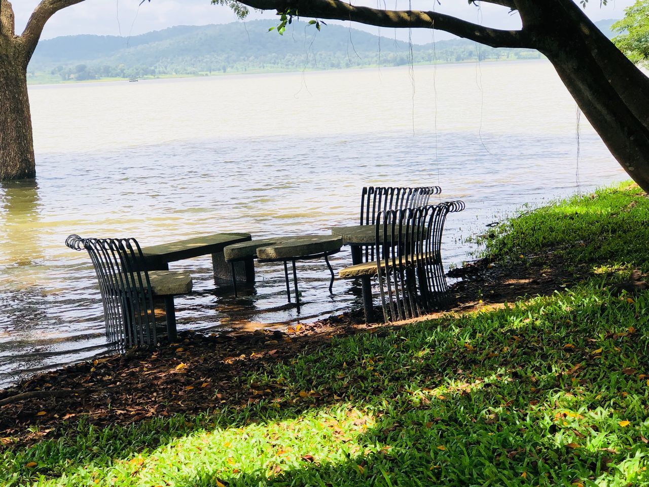 EMPTY BENCH AND TABLE IN LAKE