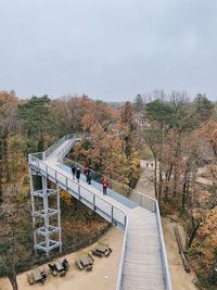 High angle view of footbridge over footpath against sky