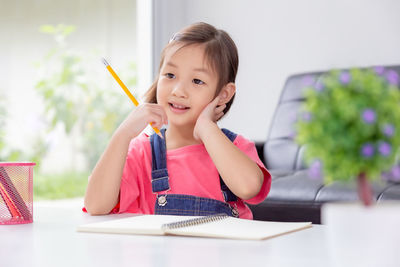 Portrait of a smiling girl sitting on table