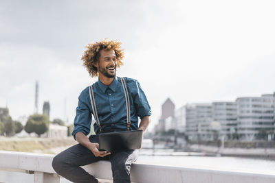 Young man using laptop outdoors