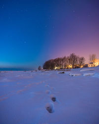 Scenic view of snow covered landscape against blue sky