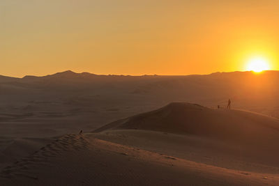 Scenic view of desert against sky during sunset