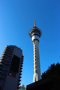 Low angle view of buildings in city against clear blue sky