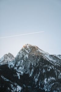 Low angle view of snowcapped mountains against clear sky