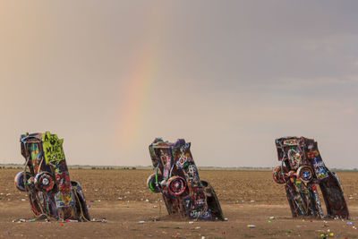 Bicycles on field by road against sky