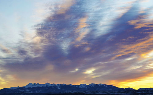 Low angle view of snowcapped mountains against sky during sunset