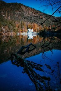 Reflection of trees in lake against blue sky