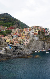 Houses by sea against sky