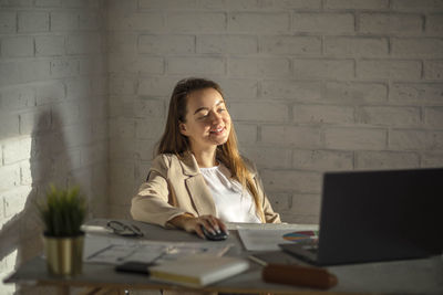 Young woman calculating success, hands-on strategies for office productivity amidst diagrams