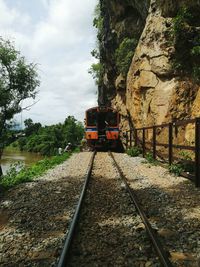 Railroad tracks by trees against sky