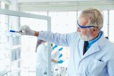 Man wearing mask standing against wall