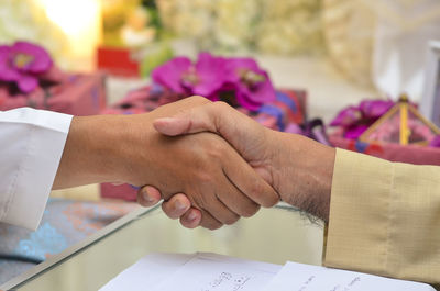 Close-up of hand shaking during the marriage settlement.