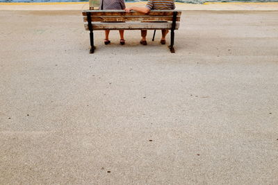 Empty bench on sand at beach