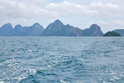 Scenic view of sea and mountains against sky
