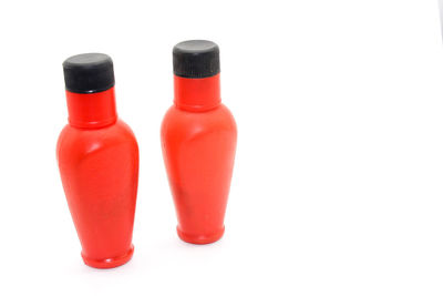 Close-up of red bottles against white background