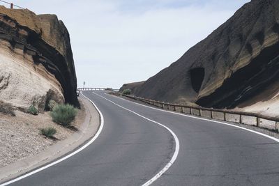 Road by mountain against sky