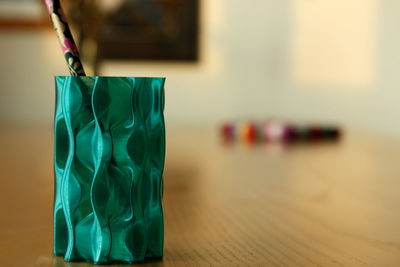 Close-up of patterned turquoise container on table